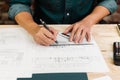 Close up hands of an engineer working and sketching on blueprints. Engineer planning project on paperwork with equipment Royalty Free Stock Photo