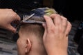 Close-up the hands of an experienced salon master, men make a fashionable haircut for a client, a guy with scissors and a comb