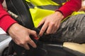 Close-up of hands fastening the seat belt of a forklift