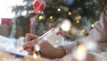 Close up hands of female writing letter and wish list at Christmas Eve. Girl writing in notebook. Woman hand holding pen Royalty Free Stock Photo