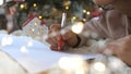 Close up hands of female writing letter and wish list at Christmas Eve. Girl writing in notebook. Woman hand holding pen Royalty Free Stock Photo