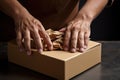 a close-up of hands folding a cardboard box for recycling