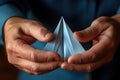close-up of hands folding a paper plane from a freshly made paper