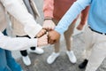 Close up hands of four multiracial people bumping their fists in city street Royalty Free Stock Photo