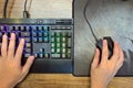 Hands of Gamer who use Mechanical Gaming Keyboard and Gaming Mouse for play game on Computer PC Desktop