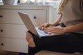 Close-up of the hands of a girl using her laptop sitting indoors. Females using technology concept