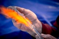 Close-up of the hands of a glassblower working on a glass object. Royalty Free Stock Photo