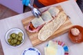 Chef preparing tasty sub sandwich from fresh ingredients.