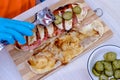 Chef preparing tasty baguette submarine sandwich.