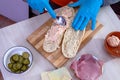 Chef preparing tasty fresh baguette sub sandwich. Royalty Free Stock Photo