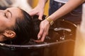 Close up of hands hairdresser washes the client`s hair. Spa, care, beauty and people concept