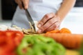 Hands of healthy young woman cutting fresh vegetables in the kitchen at home. Royalty Free Stock Photo