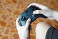 Close up hands hold black joysticks or game controller console.