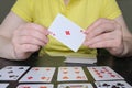 Close-up of hands holding ace of diamonds. The woman on the table is playing solitaire Royalty Free Stock Photo