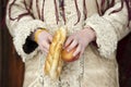 Close up of hands holding apple and pretzel of a child dressed in traditional Romanian wear Royalty Free Stock Photo