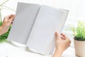 Close up of hands holding blank book beside window Royalty Free Stock Photo