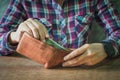 Close up of hands holding brown leather wallet full of money Royalty Free Stock Photo