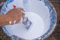 Close-up of hands holding brush dipped in paint bucket Royalty Free Stock Photo