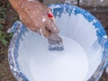 Close-up of hands holding brush dipped in a paint bucket. Repairing house and renovation concept Royalty Free Stock Photo