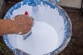 Close-up of hands holding brush dipped in a paint bucket. Repairing house and renovation concept Royalty Free Stock Photo