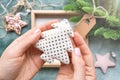 Close-up hands holding Christmas tree toy made of white fabric with gold dotted