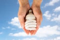 Close up of hands holding energy saving lightbulb Royalty Free Stock Photo