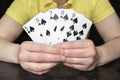 Close-up of hands holding five cards with a poker Straight Flush from a row of spades Royalty Free Stock Photo