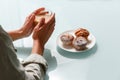 Close up of hands holding glass cup of coffee with milk and three curd muffins on plate Royalty Free Stock Photo