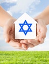 Close up of hands holding house with star of david Royalty Free Stock Photo