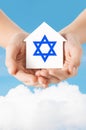 Close up of hands holding house with star of david Royalty Free Stock Photo