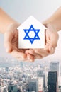 Close up of hands holding house with star of david Royalty Free Stock Photo