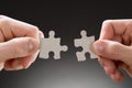 Close-up of hands holding jigsaw pieces Royalty Free Stock Photo