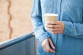 Close-up of hands holding paper take away cup of hot coffee. Royalty Free Stock Photo