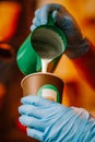 Close-up of hands holding of Professional barista pouring hot milk into coffee paper cup. Coffee making, service concept Royalty Free Stock Photo