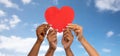 close up of hands holding red heart over blue sky Royalty Free Stock Photo