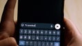 Close-up of hands holding a smartphone while typing TÃº puedes! (Cheer up!) in a messaging app. Royalty Free Stock Photo