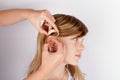 Close up of hands inserting a hearing aid in ear Royalty Free Stock Photo