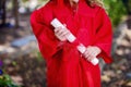 Close-up of Hands of Kindergartner in Red Graduation Gown