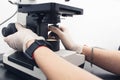 close-up of the hands of a laboratory assistant adjust the microscope for research Royalty Free Stock Photo