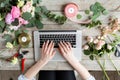 Close-up of hands, laptop keyboard and floral table. Woman blogger and content creators of social networks and blog