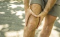 Close up hands and legs of sport man injured touching his knee in pain suffering physical problem or some injury during running Royalty Free Stock Photo