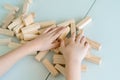 Close-up hands of little boy play with wooden bricks game