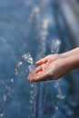 Close-up hands of a little girl catching clear blue water from a fountain Royalty Free Stock Photo