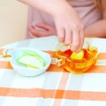 Close up of hands jewish child dipping apple slices into honey on Rosh Hashanah. Royalty Free Stock Photo