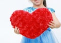 Close-up hands of little girl holding a red heart pillow isolated on white background Royalty Free Stock Photo