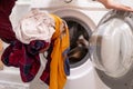 close up hands loading dirty clothes into washing machine at home bathroom f