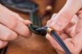 Close-up on hands making a paracord lanyard with metal bead