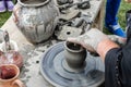 Close-up of hands making pottery from clay on a wheel.