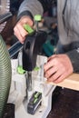 Close-up of the hands of a male carpenter set the workpiece in the clamps of a circular machine. Handwork. Starting a Royalty Free Stock Photo