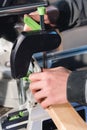 Close-up of the hands of a male carpenter set the workpiece in the clamps of a circular machine. Handwork. Starting a Royalty Free Stock Photo